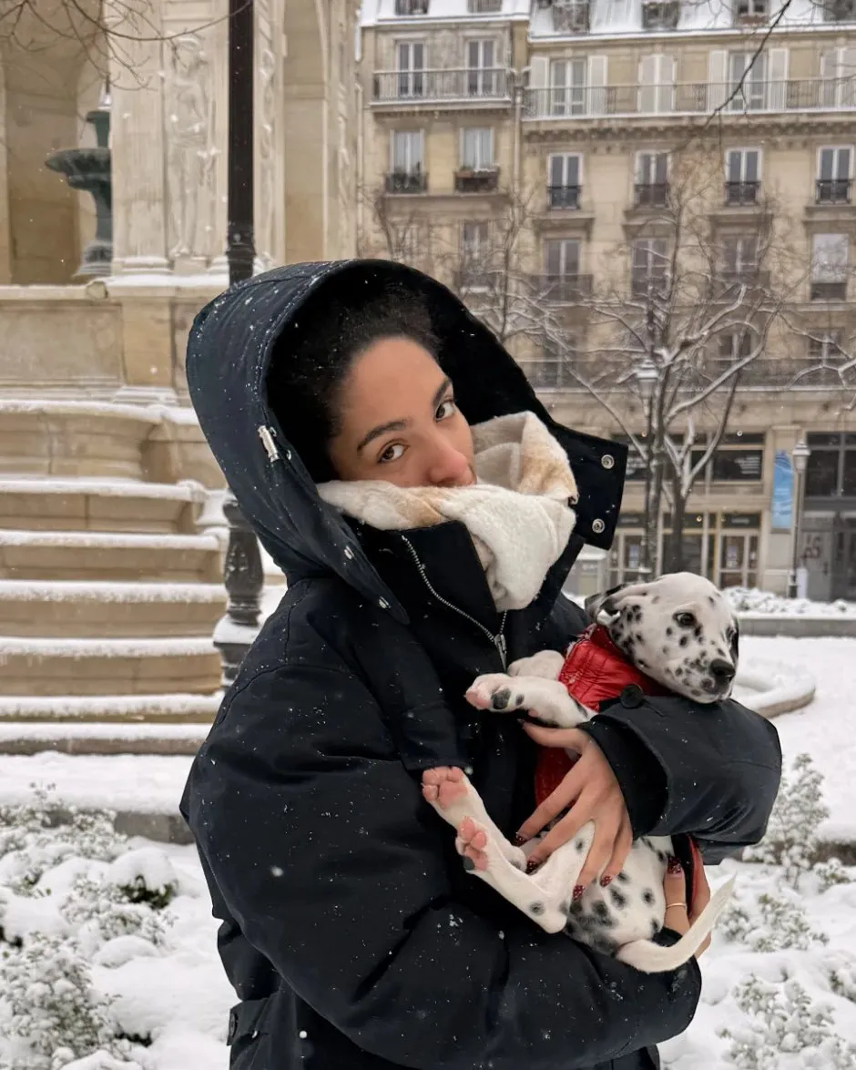 Lauryne tient Alba, encore chiot, dans ses bras, sous la neige à Paris